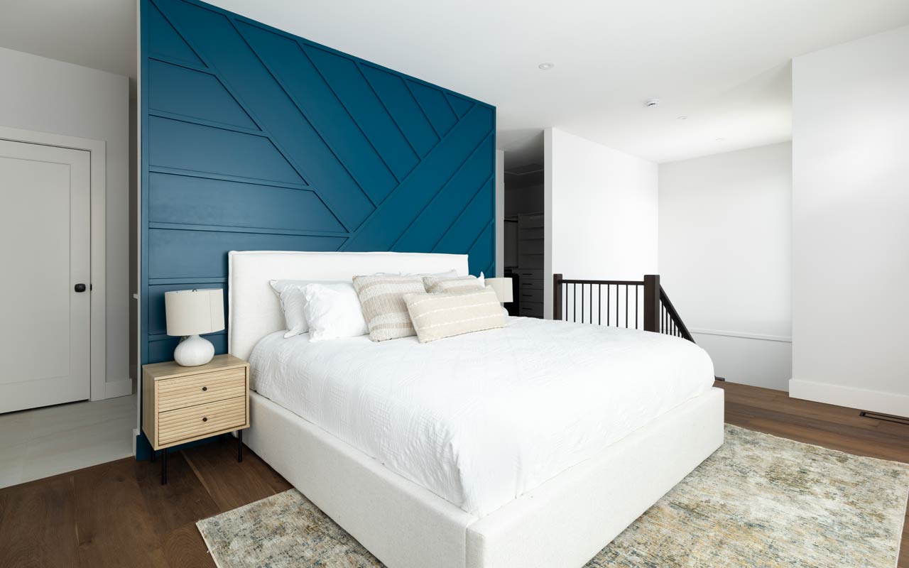 Stylish bedroom with geometric blue wall – custom feature wall painting in Kelowna